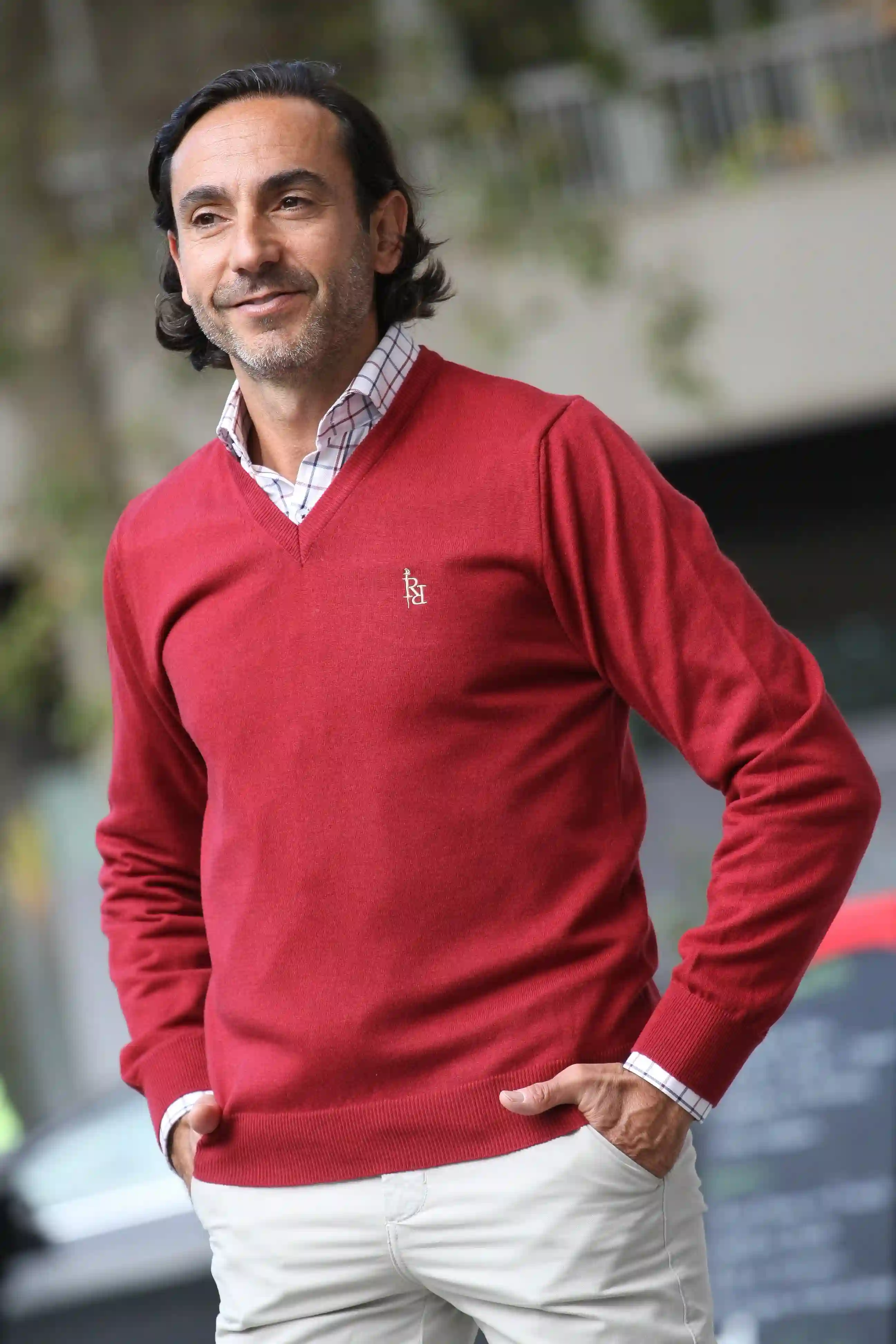 Plain red V-neck sweater with beige embroidered logo.