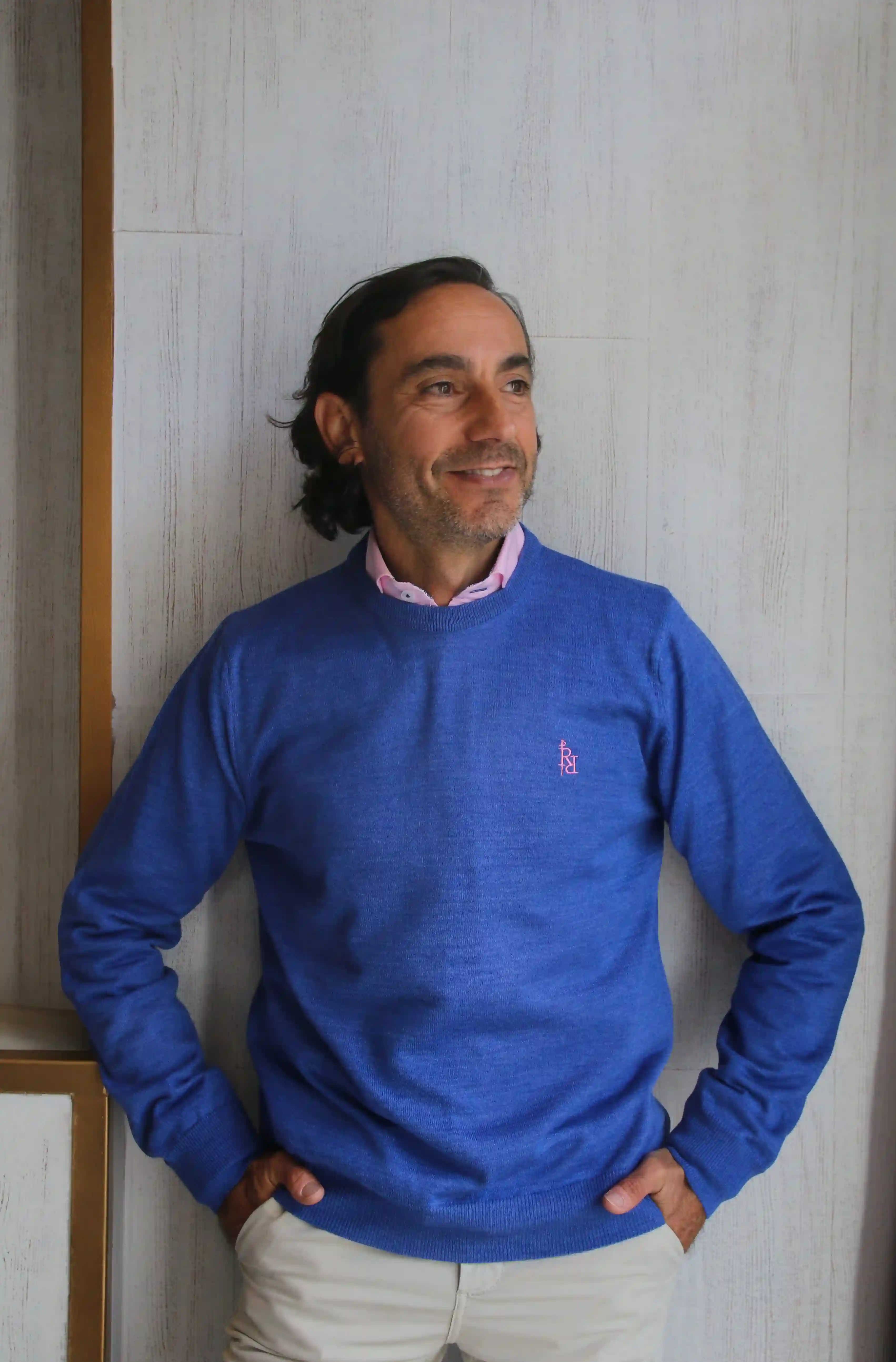 Plain blue crew neck sweater with light pink embroidered logo.