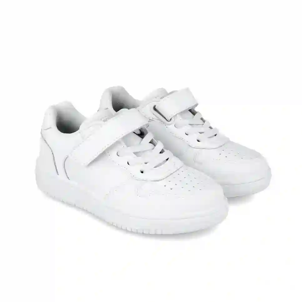 Zapatilla deportiva en piel blanca con cordón elástico y velcro. Tallas 24 a 34.