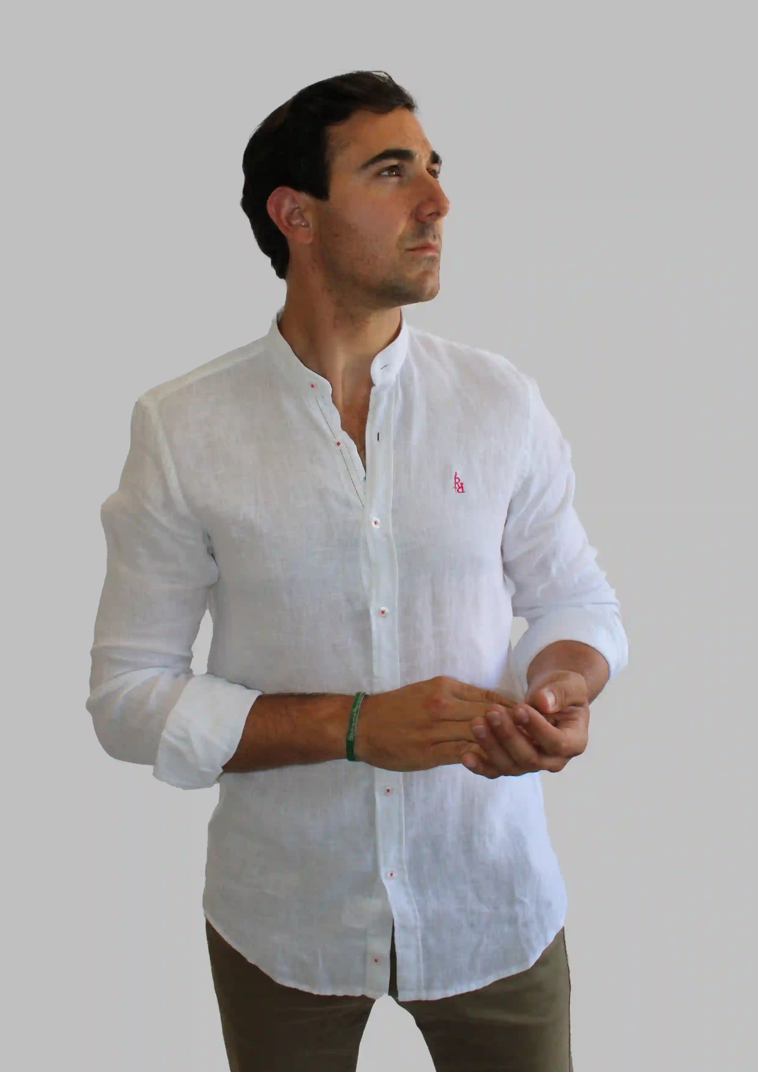 Camisa blanca de lino con logo bordado en color fucsia.