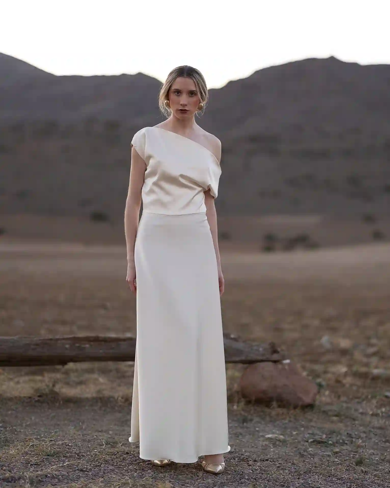 Vestido largo en satén con falda capa y cuerpo asimétrico